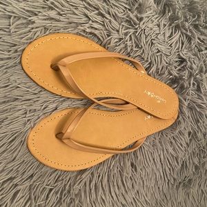 Nude faux patent leather flip flops